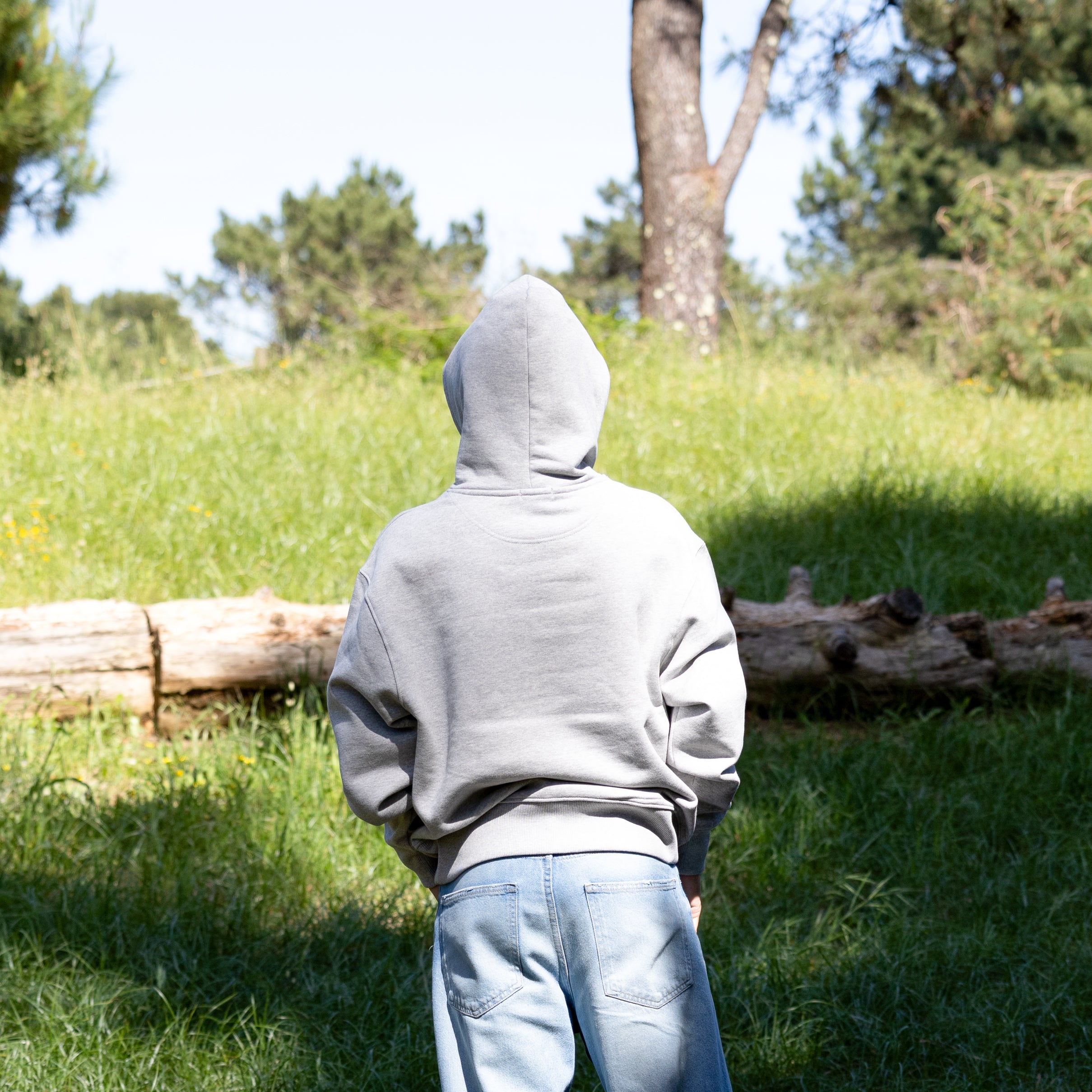 Mandelig model i grå hoodie med hætten oppe – 100% økologisk bomuld og afslappet pasform