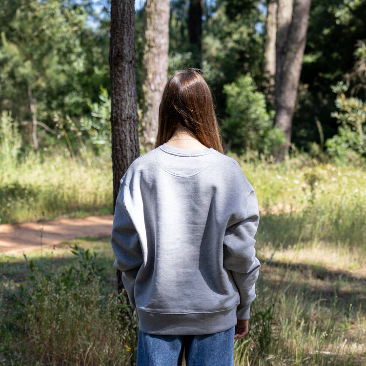 Kvindelig model i grå økologisk sweatshirt set bagfra – GOTS-certificeret og dansk design, produceret i Portugal