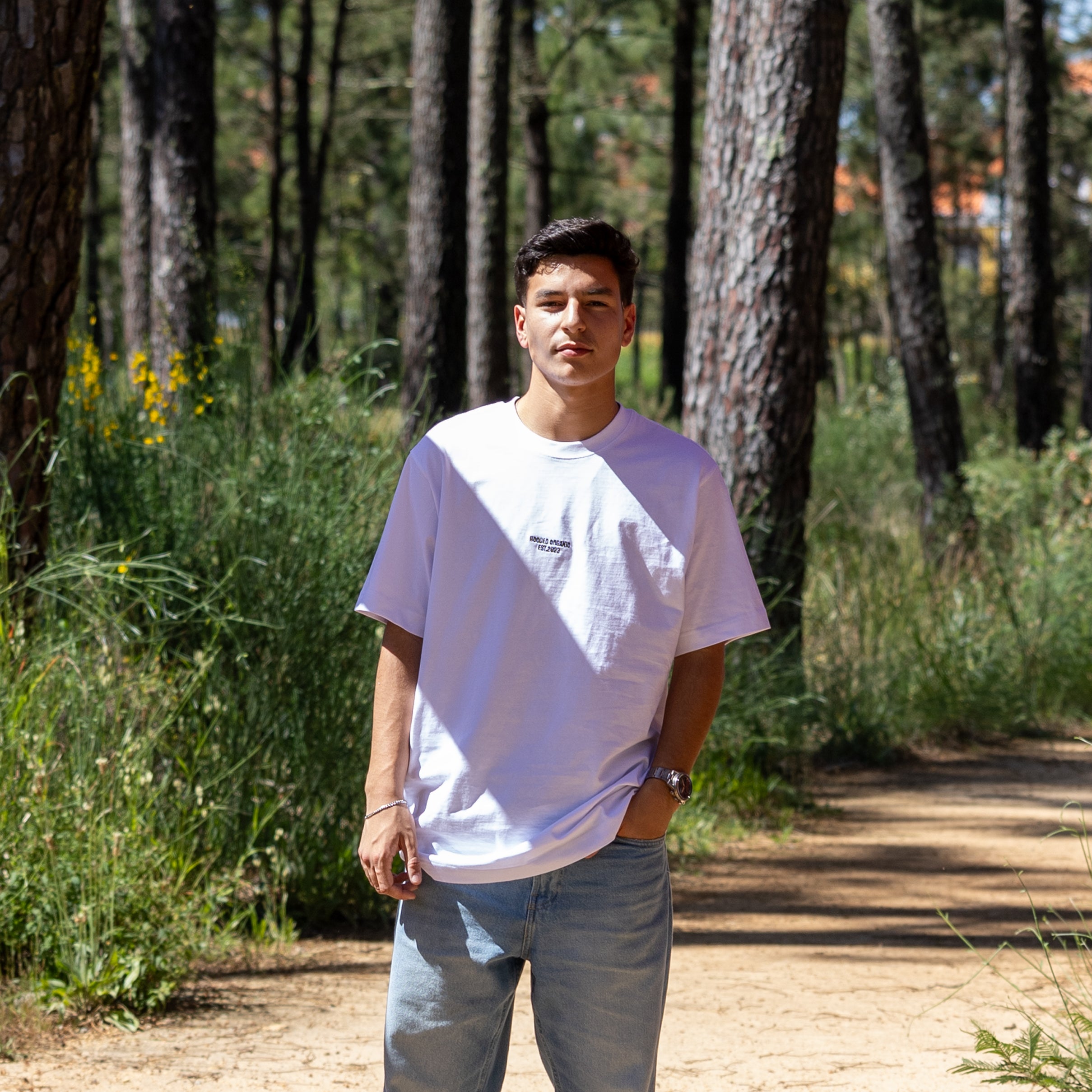 Hvid T-shirt med Hooded Organic-logo på mandelig model – comfy loose fit i 100% økologisk bomuld
